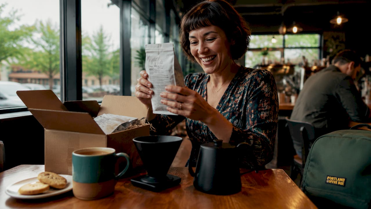 Woman unpacking fresh coffee gift box