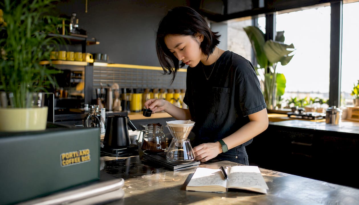 Woman weighing coffee grounds for brewing