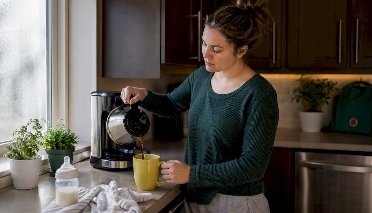 New mother pouring quick brewed coffee in kitchen