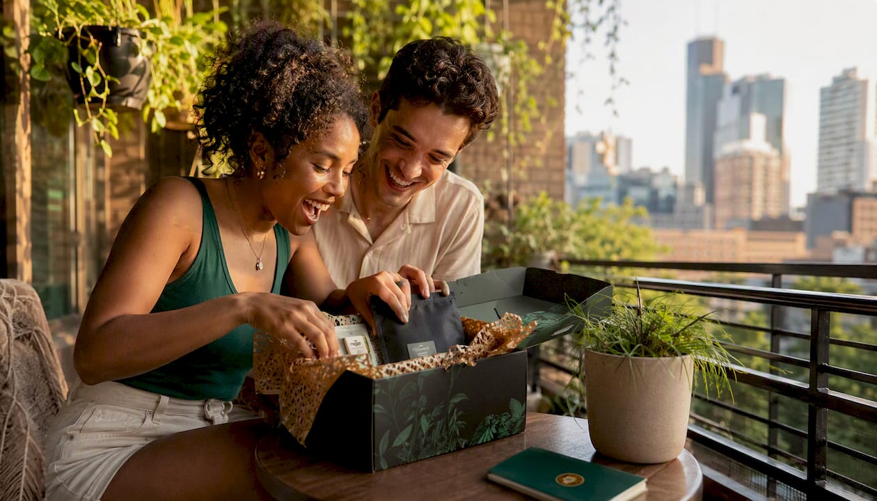 Newlyweds opening subscription gift box in living room